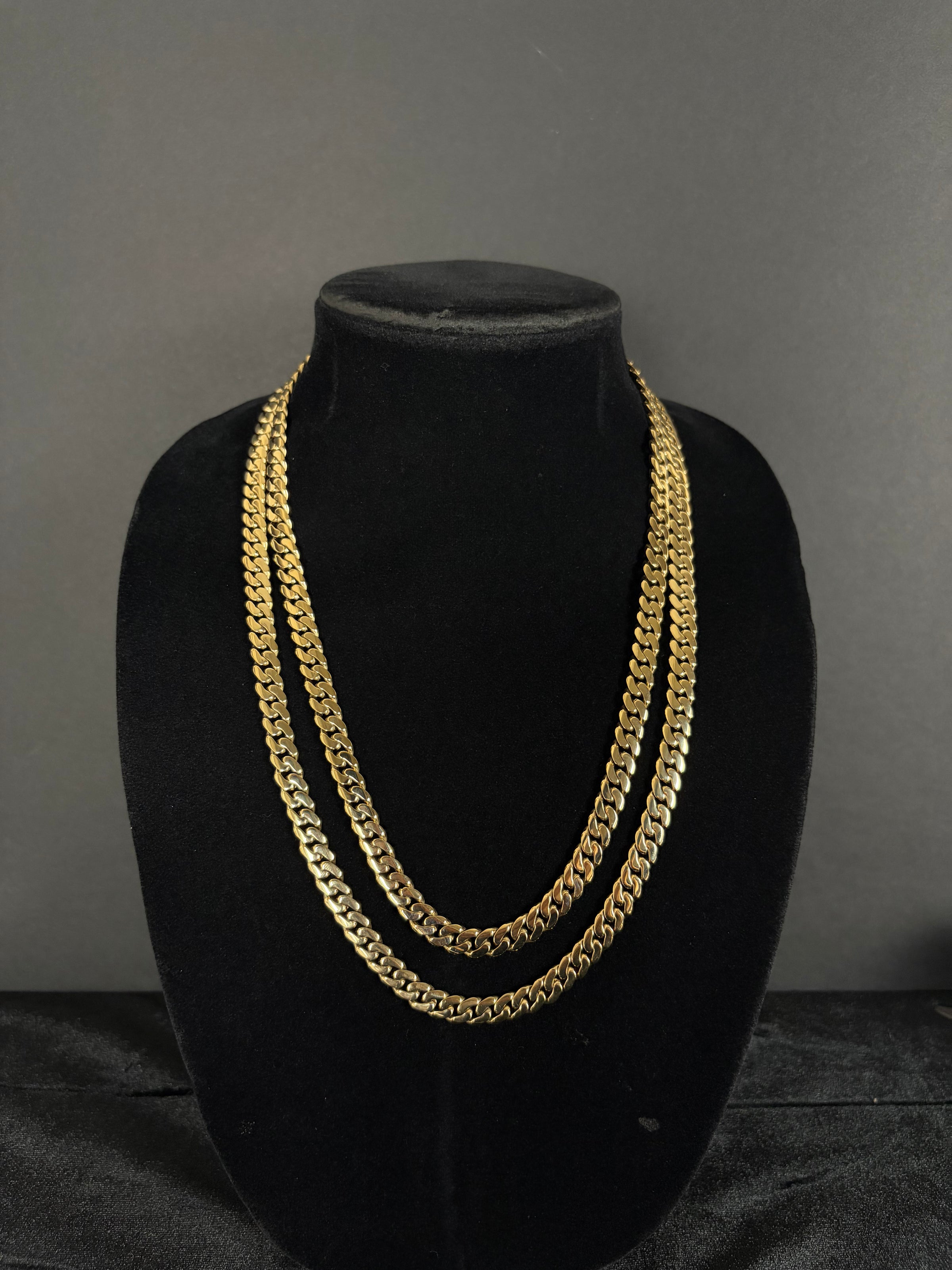 Two Monaco chains layered on a black velvet display