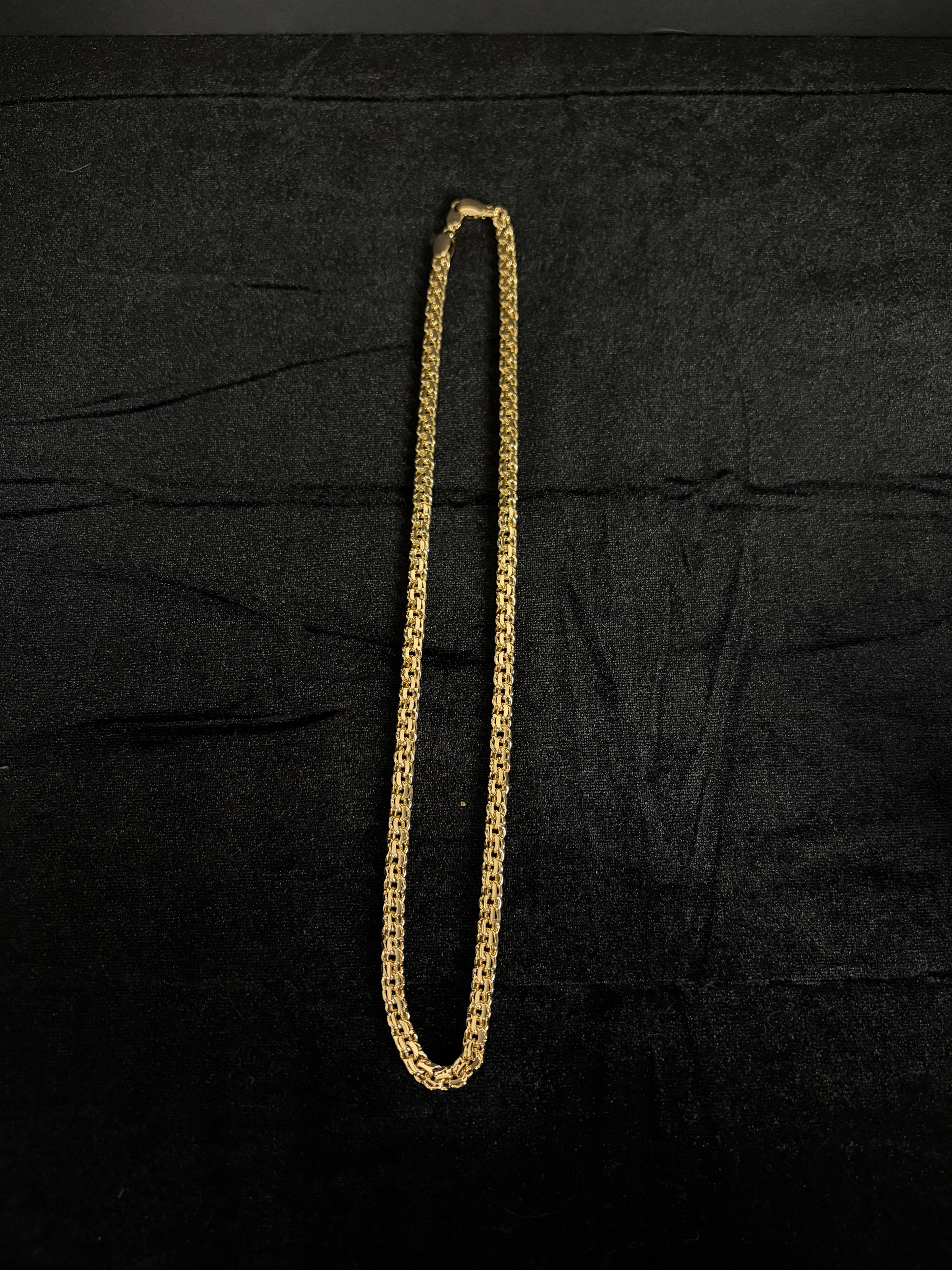 Full-length view of the 22-inch Chino Link chain laid on dark fabric