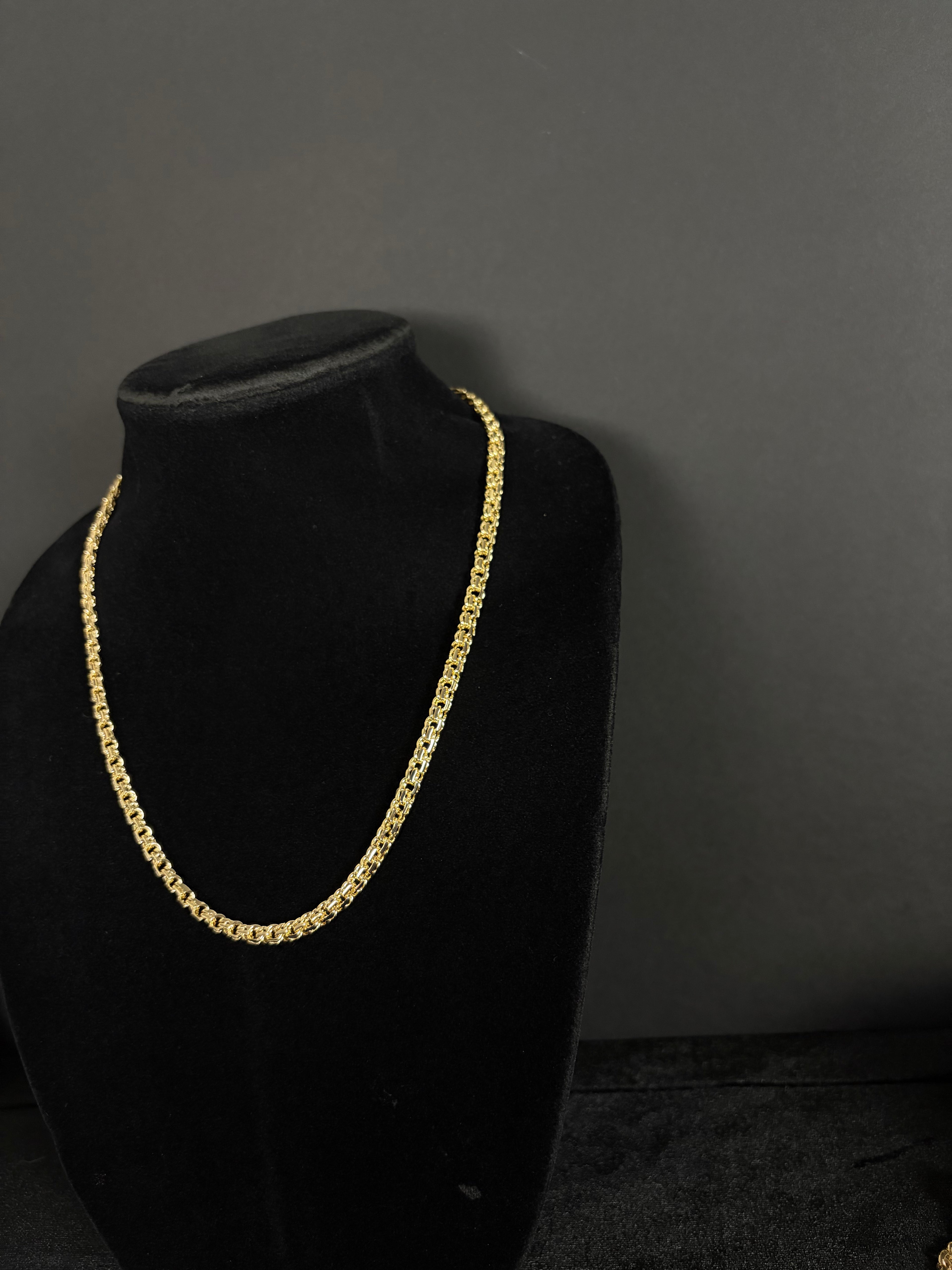 Angled view of the 22-inch Chino Link chain on a black velvet display