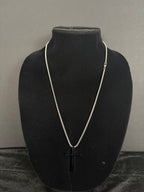 Silver-tone cross necklace — front view on a black display