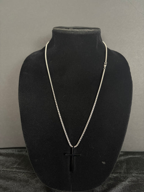 Silver-tone cross necklace — front view on a black display